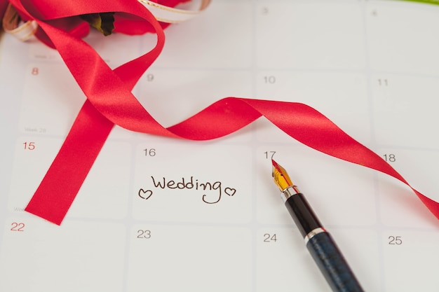 Recordatorio día de la boda en la planificación del calendario y pluma estilográfica con tono de color.