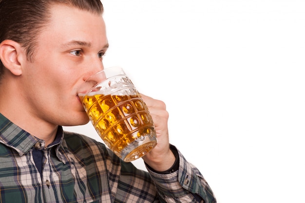 Foto recortada cerca foto de estudio de un joven apuesto disfrutando de beber cerveza