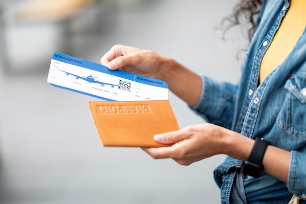 Foto recortado de manos femeninas con billetes de avión y pasaporte