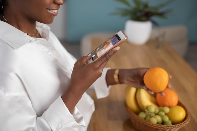 Recortado de una mujer negra tomando una foto del espacio de una copia naranja