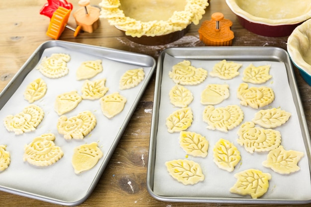 Recortando hojas de otoño con estampadora de galletas para decorar la tarta de calabaza.