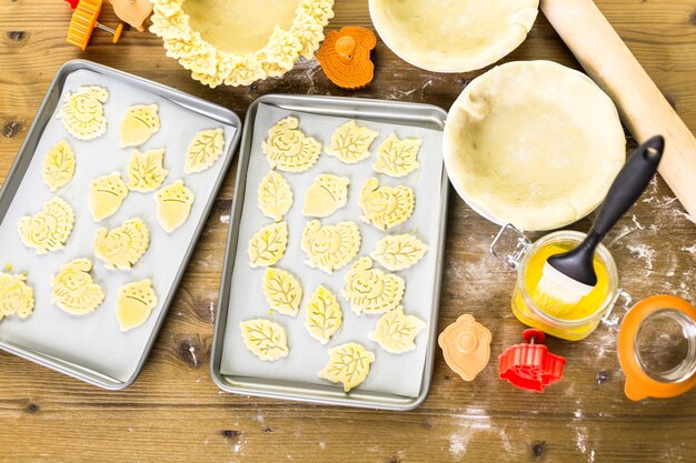 Recortando hojas de otoño con estampadora de galletas para decorar la tarta de calabaza.