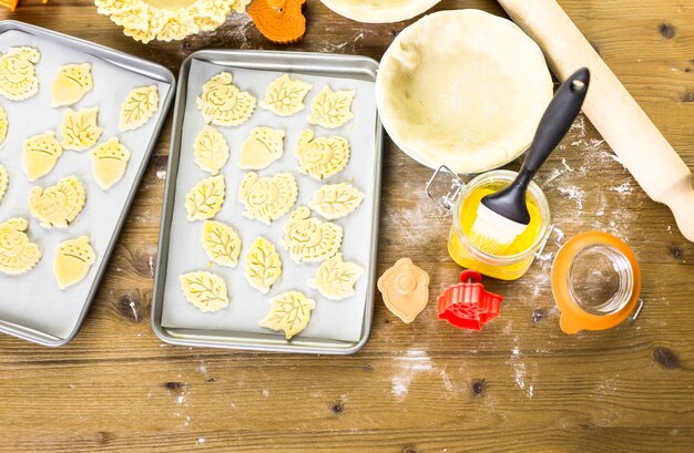 Recortando hojas de otoño con estampadora de galletas para decorar la tarta de calabaza.