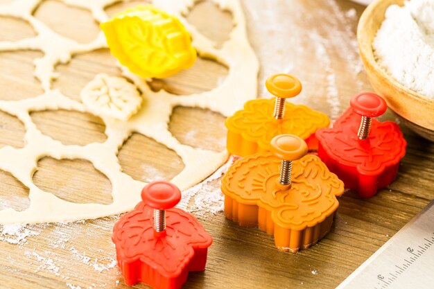 Recortando hojas de otoño con estampadora de galletas para decorar la tarta de calabaza.