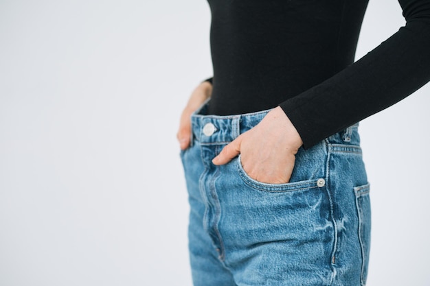 Recortar foto de mujer hermosa joven en manga larga negra y jeans en el fondo blanco aislado