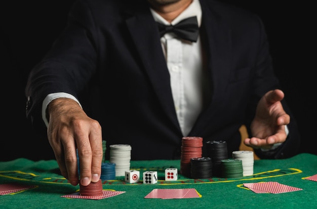 Recortar imagen de hombre de cerca distribuidor o croupier baraja cartas de póquer apostando con fichas en el casino de mesa verde Invitación de hombre distribuidor apostar naipes Concepto de juego de póquer de póquer de casino