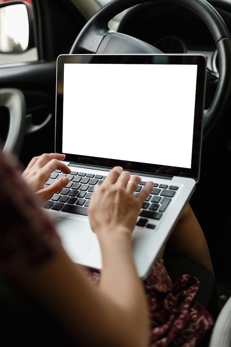 Foto recortar la imagen de la maqueta de una mujer casual mirando y usando una computadora portátil mientras está sentada en el asiento del conductor en el automóvil