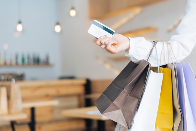 Recortar la mano con bolsas de papel y tarjeta de crédito