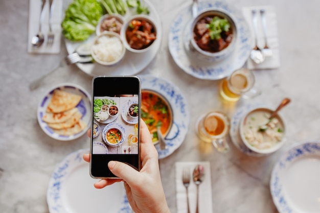 Recortar a mano tomando fotos de comida en la mesa