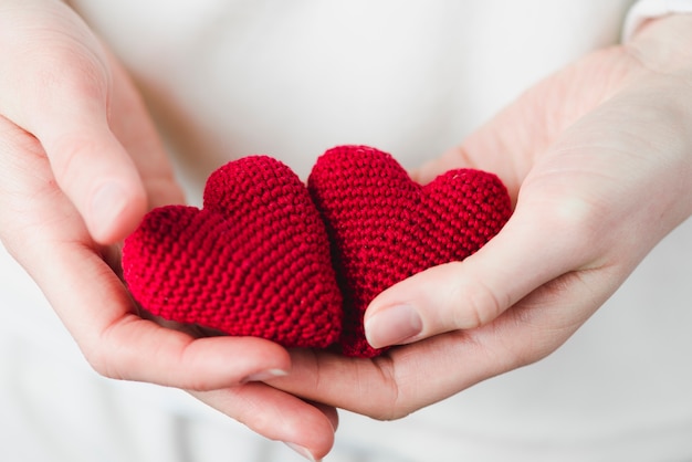 Foto recortar las manos con corazones tejidos