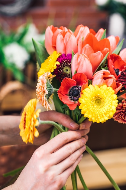 Recortar las manos femeninas con flores de colores