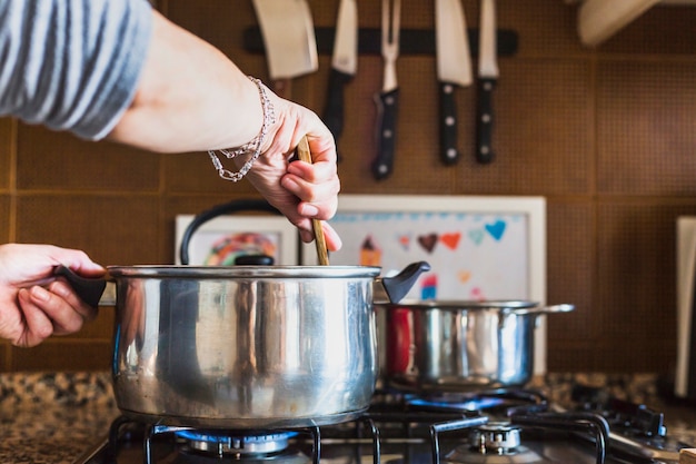 Recortar las manos de mujer cocinando en la cocina