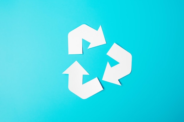 Recorte del logotipo de reciclaje de papel sobre fondo azul Protección del medio ambiente Cero desperdicio Reutilizable Di no plástico Día mundial del medio ambiente Día de la ecología y concepto del día de la Tierra