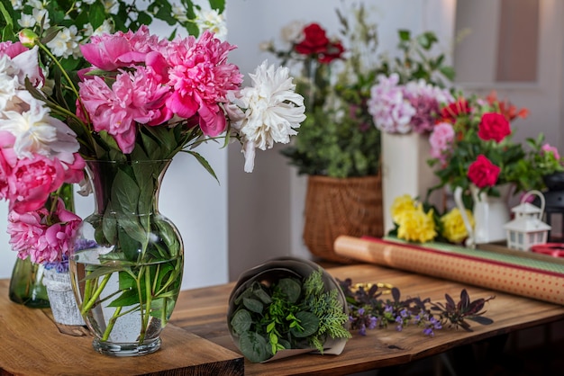 Recorte o vaso de vidro mais saller com peônias florescendo. Arranjo de buquês