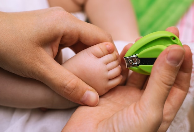 Recorte de uñas para un niño pequeño. Pedicure. Pequeños pies y manos de mamá. Higiene.