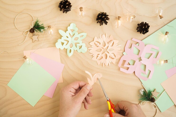 Foto recortes de copos de nieve de papel de colores sobre un fondo de madera cortar copos de nieve de papel de colores fondo de invierno de copo de nieve idea de manualidades de invierno simple para niños