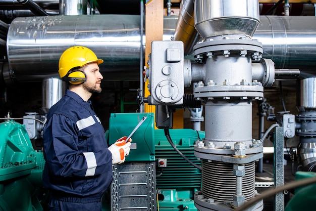 Foto recruta de fábrica verificando motores de gerador e produção em usina