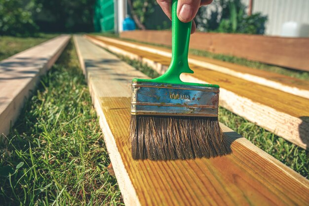 Foto recubrimiento de las tablas de madera con un antiséptico con una construcción de pincel