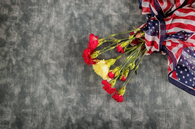 Foto recuerdo de flores de clavel rosa para el día de la celebración conmemorativa con la bandera estadounidense
