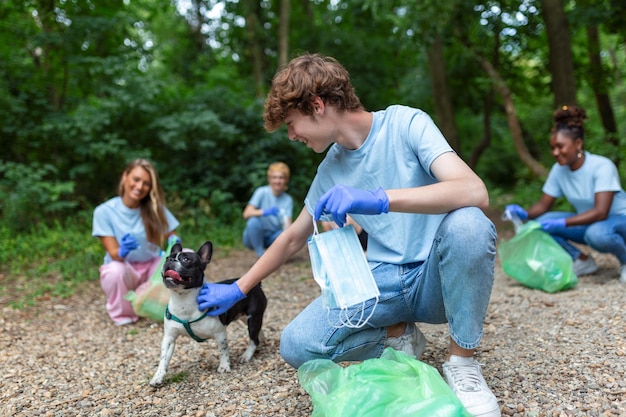 Recyceln Sie Abfall Abfall Müll Müll Junk Clean Training Naturreinigung Freiwilliger mit seinem Hund Ökologie grünes KonzeptUmweltverschmutzung durch Plastik