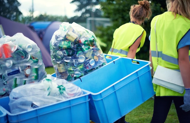 Foto recycling-gemeinschaftsdienst und freiwilligenarbeit im freien mit dosen und müll in einem park. nachhaltige reinigung und flaschenrecycling mit menschen, die mit müll und umweltverschmutzung helfen