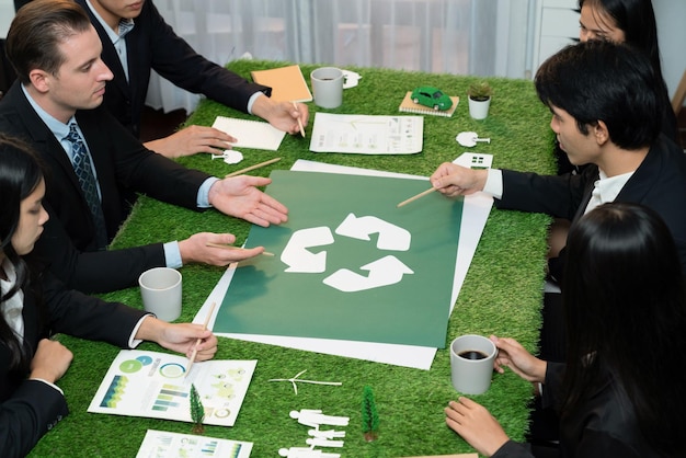Foto recycling-symbol auf dem sitzungstisch im büro mit geschäftsleuten, die öko-business-investitionen in die abfallwirtschaft planen, als recycling-reduzierungs-wiederverwendungskonzept für ein sauberes ökosystem