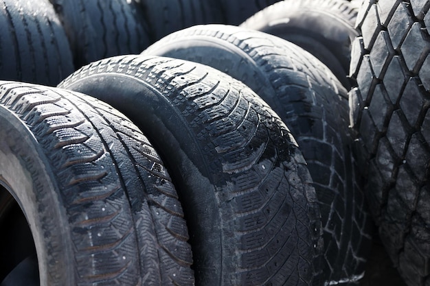 Recycling von Autoreifen für Lastwagen That39s viele schwarze kahle Gummireifen, die draußen in einer offenen Lagerhalle liegen