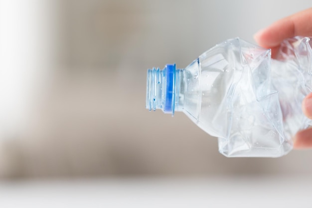 recycling, wiederverwendung, müllentsorgung, umwelt- und ökologiekonzept - nahaufnahme der hand, die gebrauchte zerschmetterte plastikflaschen hält