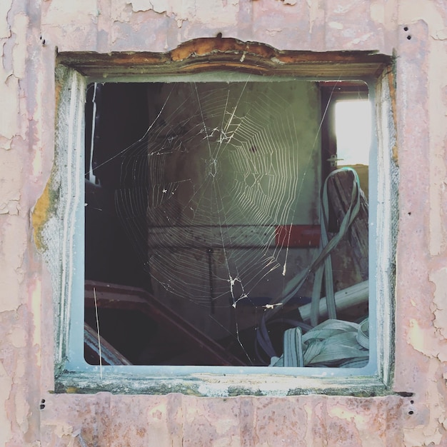 Foto red de araña en una ventana abandonada