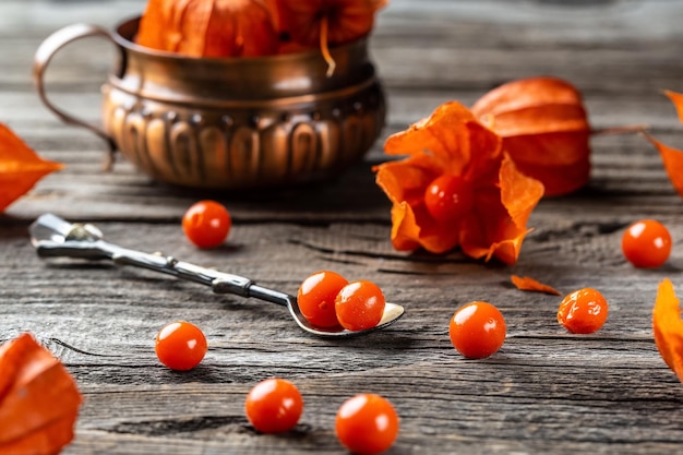 Red Cape Stachelbeere Beeren Früchte Physalis oder chinesische Laternenpflanzen auf alten Küchentisch