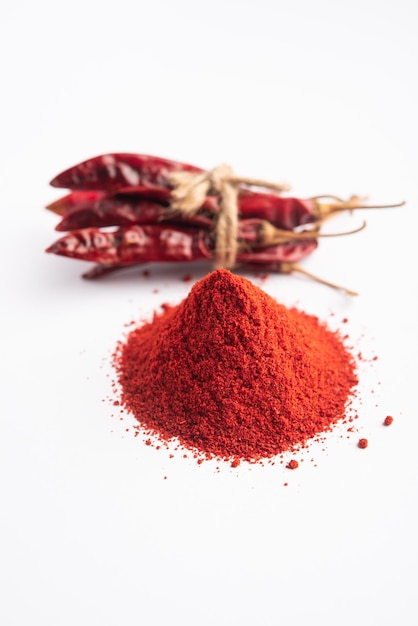 Red Chilli oder Lal Mirchi oder Mirch mit Pulver in einer Schüssel oder einem Mörser über stimmungsvollem Hintergrund, selektiver Fokus