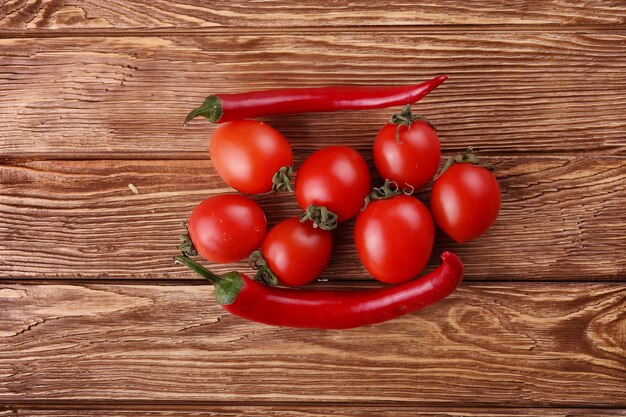 Red hot cherry y chiles sobre madera blanca