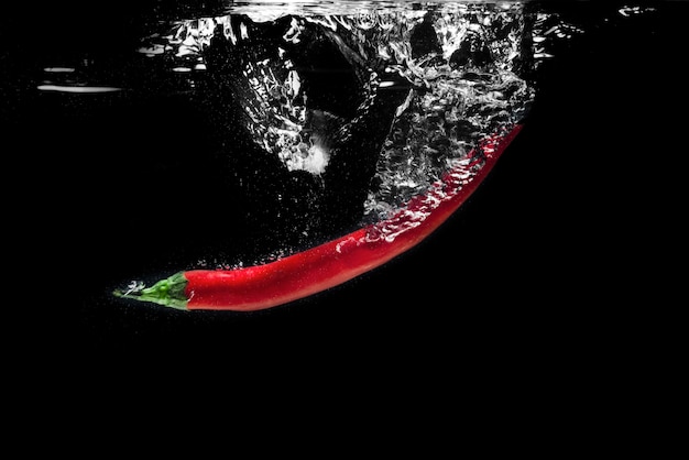 Red hot chili pepper chapoteando en el agua