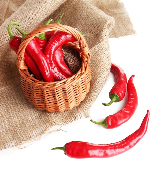 Red hot chili peppers em pano de saco de cesta de vime isolado no branco