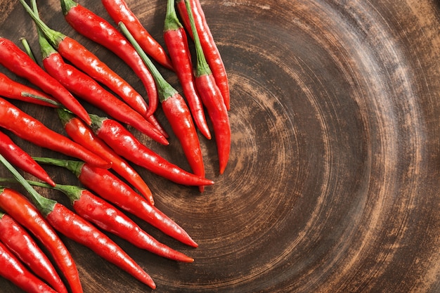 Red hot chili peppers en placa de arcilla marrón. Copia espacio Ciérrese encima de las pimientas picantes frescas. Vista desde arriba.
