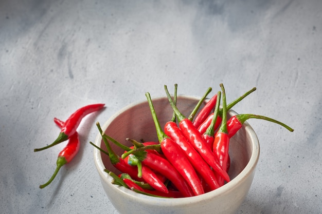 red hot chilli peppers em tigela de cerâmica na mesa de luz.