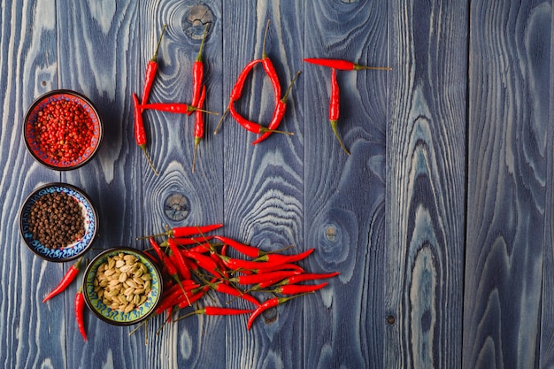 Red hot thai chiles en una palabra "hot" en una tabla de cortar
