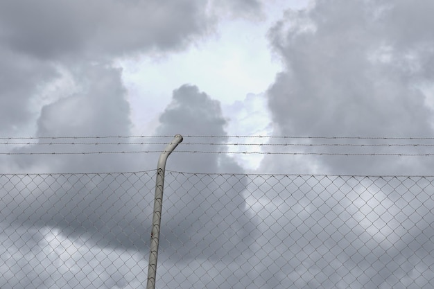 Red metálica gris contra el cielo oscuro Conceptual para el conflicto fronterizo de seguridad de crisis