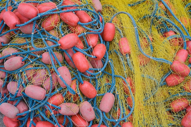 La red de pesca con cuerdas y flotadores se está secando en el enfoque selectivo del primer plano del muelle