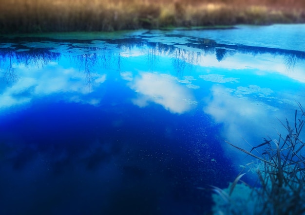 Red de pesca diagonal en el lago de otoño con fondo de reflejos del cielo