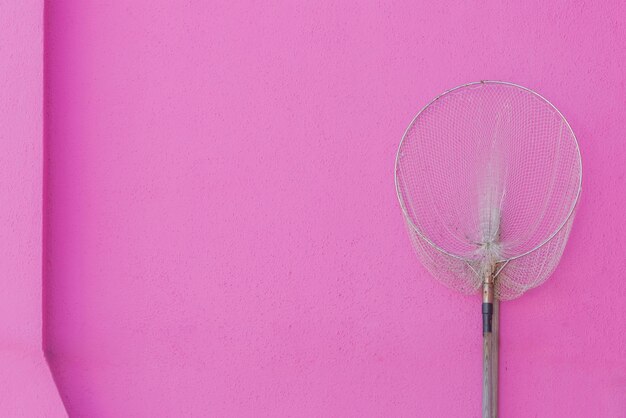 Foto red de pesca sobre un fondo de pared de color fucsia