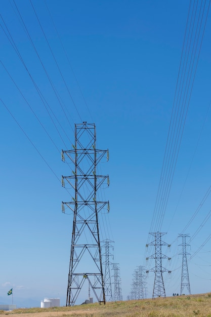 Red de torres de energía con fondo de cielo azul. plano vertical