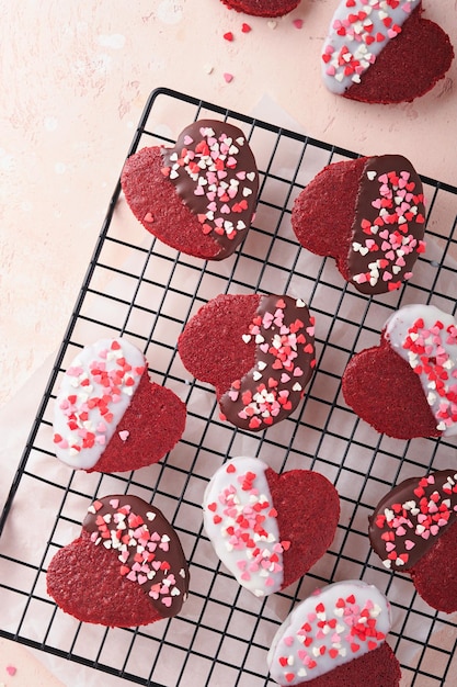 Red Velvet oder Brownie Cookies auf Herz geformt in Schokoladenglasur auf einem rosa romantischen Hintergrund Dessert-Idee für den Valentinstag Mutter- oder Frauentag Leckeres hausgemachtes Dessert Kuchen zum Valentinstag