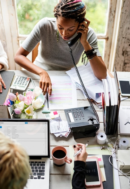 Foto redakteurin, die am telefon im büro spricht