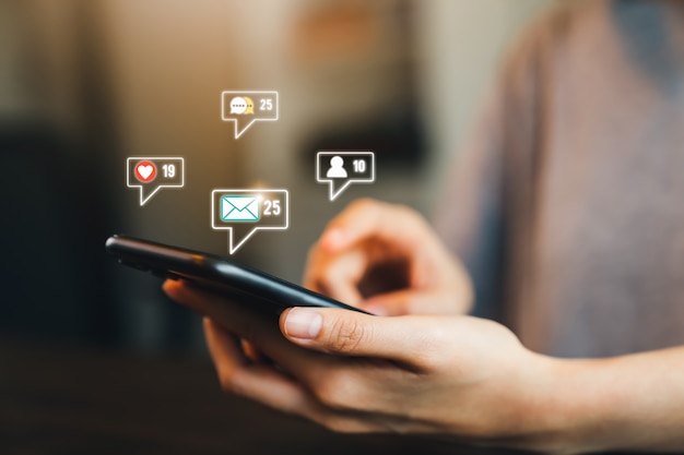 Rede de comunicação do conceito. Mão de mulher pressione o telefone e mostre o ícone do e-mail no celular.