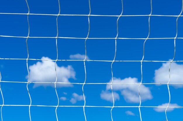 Foto rede de futebol de futebol com céu azul e nuvens brancas