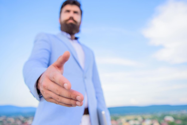 Foto rede de oportunidades de negócios junte-se ao meu negócio venha conexões de negócios mão do empresário oferece a mão para o fundo do céu azul do aperto de mão gesto ou oportunidade amigável do aperto de mão