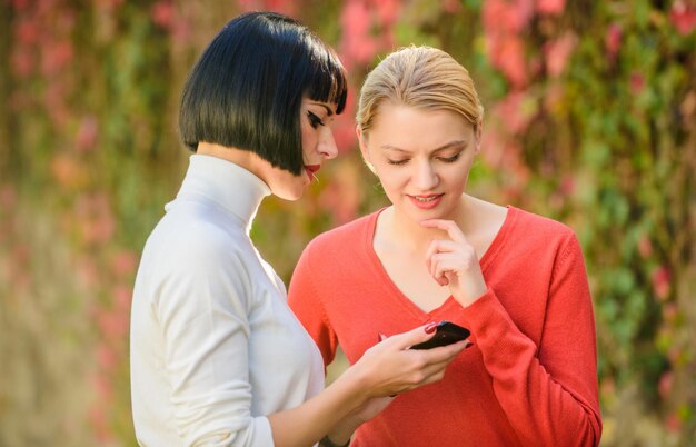 Rede social basta olhar para esta internet móvel 3g 4g navegando na internet marketing digital duas mulheres felizes olham no telefone comprar online na cyber segunda-feira sexta-feira negra compras online comunicação empresarial