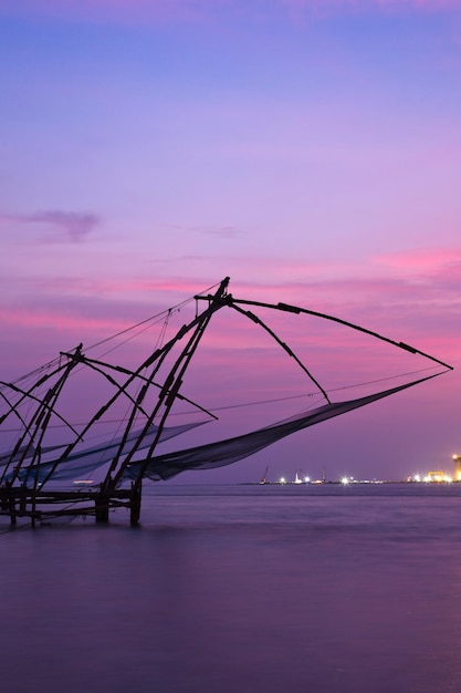 Redes de pesca chinesas no pôr do sol Kochi Kerala Índia