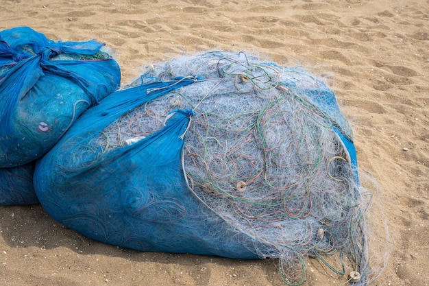 Redes de pesca coletadas na praia de areia Redes de pesca de náilon secam na praia